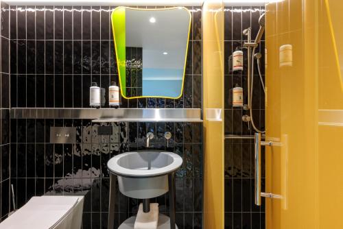 悉尼Adge Hotel and Residences的一间带水槽、镜子和卫生间的浴室