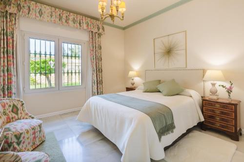 多列毛利诺斯Villa Galemar Pool & Gardens的卧室配有床、椅子和窗户。