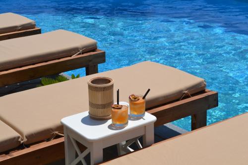 加夫里翁Charakas Horizon的游泳池畔的桌子上放着两杯饮料