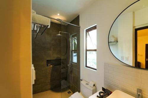爱妮岛J Boutique Hotel El Nido的带淋浴和镜子的浴室