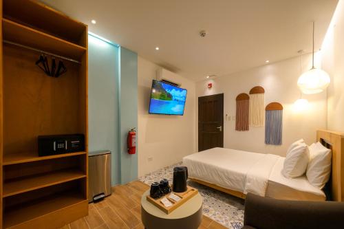 爱妮岛J Boutique Hotel El Nido的一间酒店客房,配有一张床和一台电视