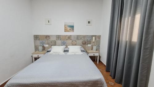 加的斯卡纳莱哈斯旅馆的一间卧室设有两张床和窗户。