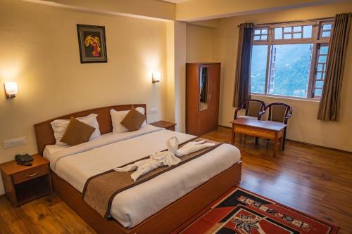 BhurtukThe Loft Norling Hotel & Spa的一间卧室设有一张大床和大窗户