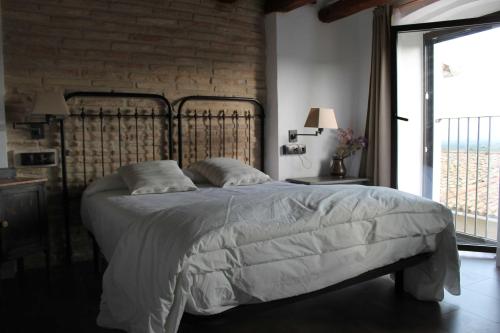 TivissaCA LA MUM的一间卧室设有一张带砖墙的大床