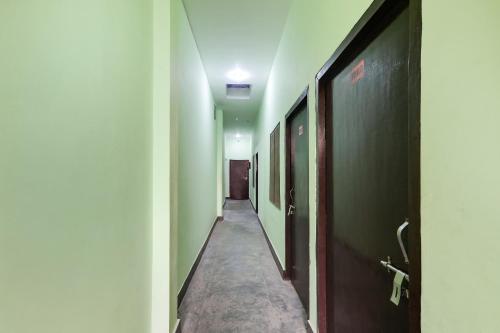 勒克瑙Relax Inn Hotel的一条带绿色墙壁和长走廊的走廊
