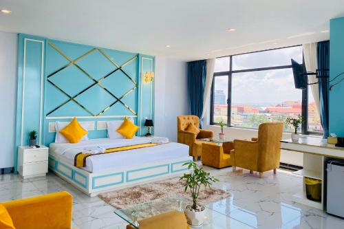 贡布Kampot Sunny Hotel的卧室配有一张床、一张桌子和椅子