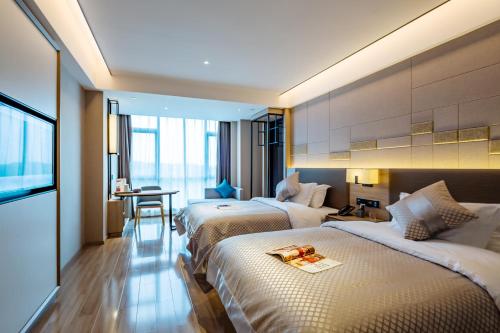 谷塘莫林酒店长沙黄花国际机场店的酒店客房设有两张床和一张桌子。