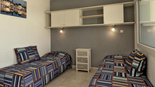 勒格罗-迪鲁瓦Residence Ulysse Port Camargue的一间卧室配有两张床和橱柜
