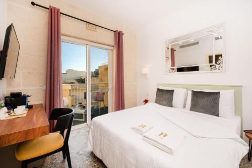 维多利亚Battistini Boutique Living Hotel and Spa, Victoria, Gozo的一间卧室配有一张床、一张书桌和一个窗户。