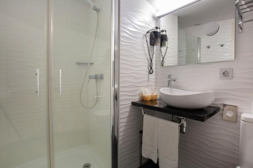 马萨纳Hotel Del Pui的一间带水槽和淋浴的浴室