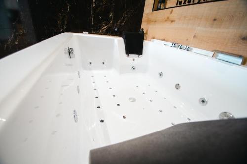 韦尔瓦LUZ DE PATIOS的白色浴缸及黑色台面