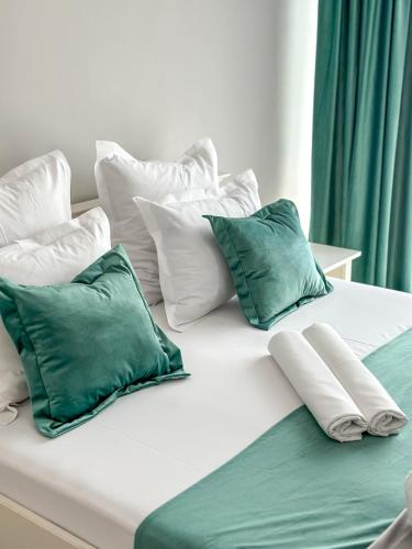 泰基尔吉奥尔House Lake的白色的床和绿色的白色枕头