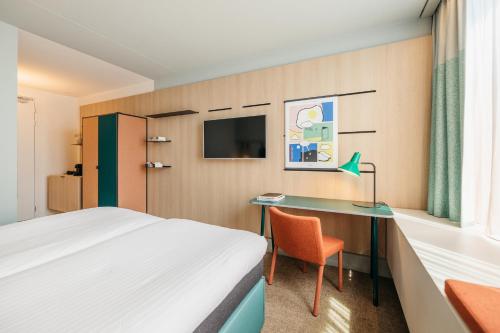 阿姆斯特丹阿姆斯特丹之家酒店的配有一张床和一张书桌的酒店客房