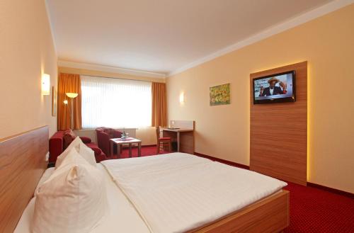 诺伊鲁平诺伊鲁平运动酒店的酒店客房,配有床和电视