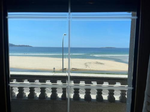尼格兰PLAYA AMERICA MAR的从窗户可欣赏到海滩美景