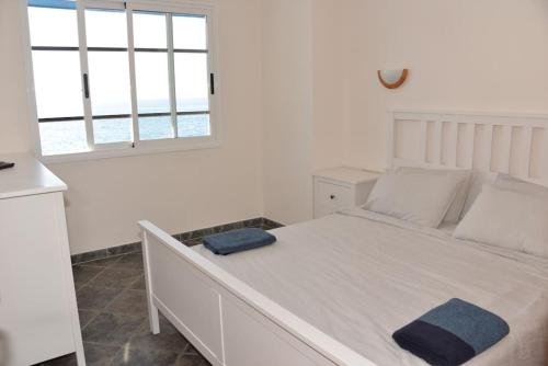 圣克鲁斯-德特内里费Beachfront Apartment - Tacoronte的卧室配有一张大白色床和窗户
