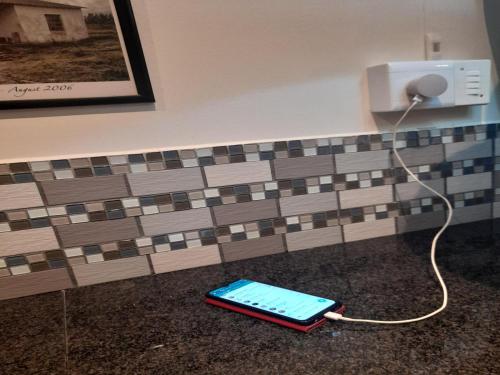 帕尔帕达布特自助式小屋酒店的充电器旁边的地板上的手机
