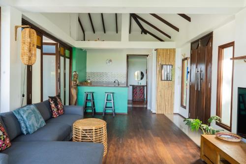 涛岛Banana Villa Koh Tao的一间带蓝色沙发的客厅和一间厨房