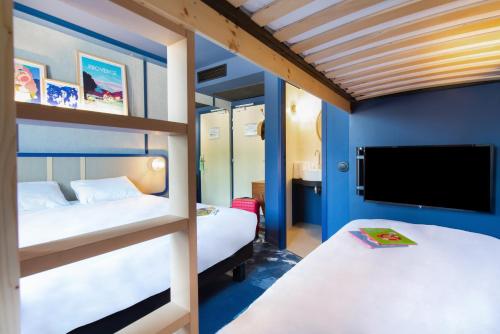 普罗旺斯地区萨隆greet hotel Salon de Provence的一间卧室配有两张双层床和一台平面电视