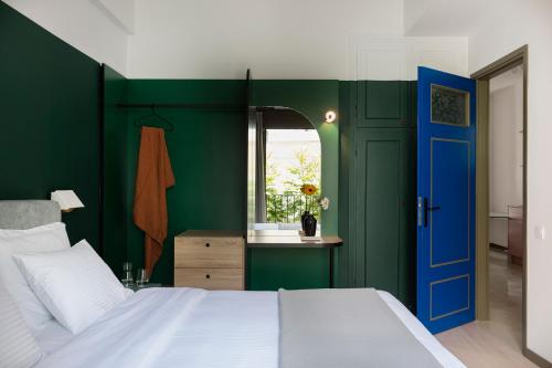 雅典Nileos House的一间卧室设有绿色的墙壁和蓝色的门