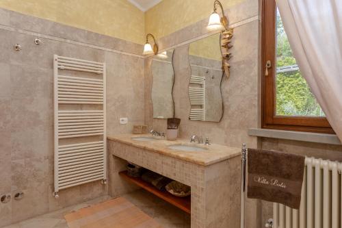 特拉诺瓦-布拉乔利尼Villa Lolù的一间带水槽和镜子的浴室以及窗户。