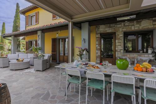 特拉诺瓦-布拉乔利尼Villa Lolù的户外庭院配有桌椅和水果