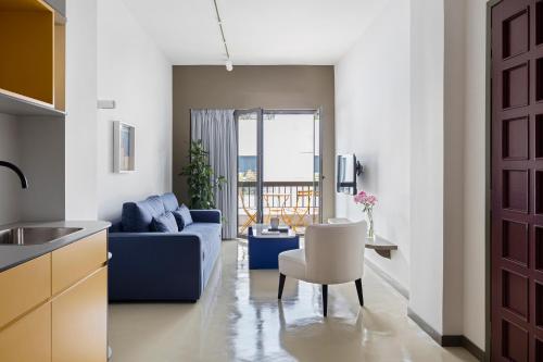 雅典Nileos House的客厅配有蓝色的沙发和桌子