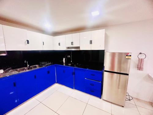 苏瓦HomeStay Inn的厨房配有蓝色橱柜和不锈钢冰箱