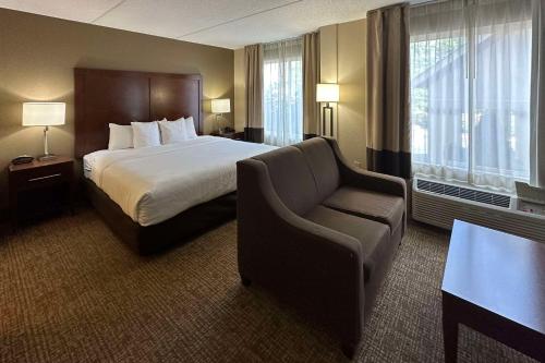 夏洛特Comfort Suites Airport的配有一张床和一把椅子的酒店客房