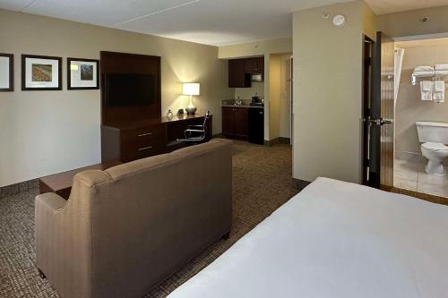 夏洛特Comfort Suites Charlotte Airport的酒店客房设有沙发和浴室。