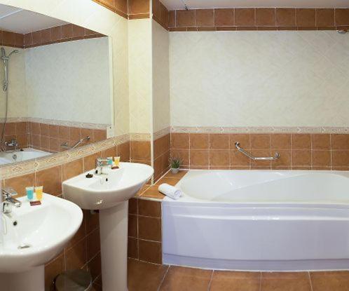 奥亨Hotel Wellness Marbella Hills的带浴缸、水槽、浴缸和镜子的浴室