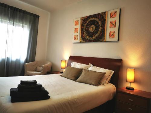 锡尼什Gustavo's Place的一间卧室配有一张带两盏灯和一把椅子的床。