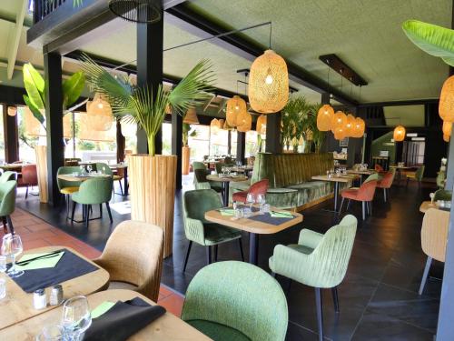 里摩日Hotel Be Guest Limoges Sud - Complexe BG的一间设有桌椅的餐厅,种植了植物