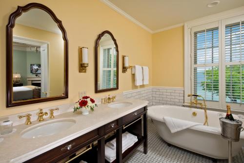 库珀斯敦The Otesaga Resort Hotel的浴室设有2个水槽、浴缸和镜子