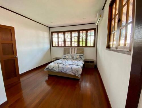 TelukmataikanPrivate Tropical 3 Bedroom Villa - Nongsa Village Batam的卧室位于客房的角落,配有一张床