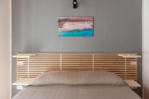 锡库利亚纳La Casetta di Giorgio的卧室配有一张床,墙上挂有绘画作品