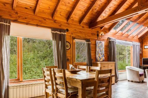 拉安戈斯图拉镇BOG Melania - casa en el bosque的一间带桌椅和窗户的用餐室
