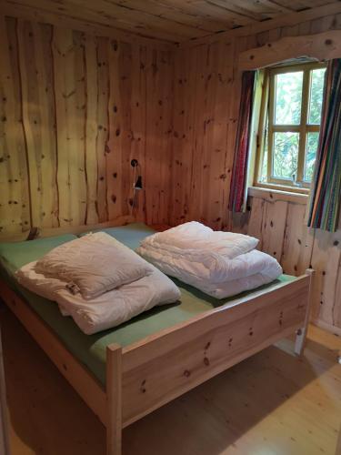 卑尔根Fanafjorden Cabins的木制客房内的一张床位,上面有两个枕头