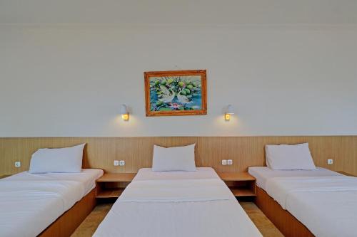 勒吉安Guest House Simalem的墙上有照片的房间,有三张床