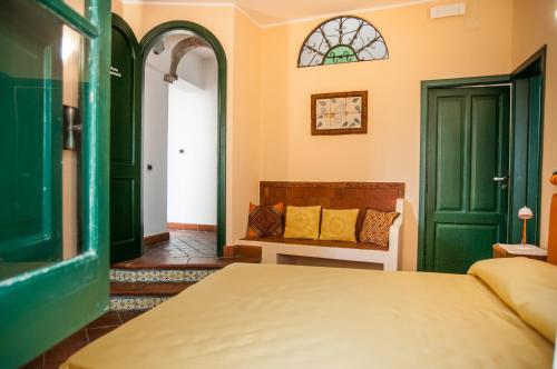 陶尔米纳卡萨安德烈住宿加早餐旅馆的一间卧室设有绿门、一张床和长凳