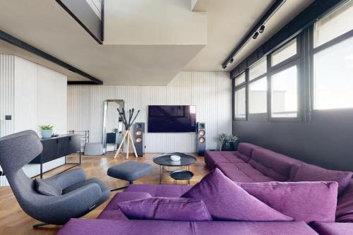 布拉迪斯拉发Štýlový loft s ohromnou terasou的客厅配有紫色家具和紫色沙发