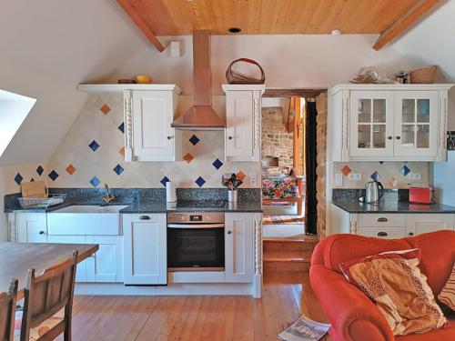 迪南Val Rive - Fryer Apartment的厨房配有白色橱柜和炉灶烤箱。
