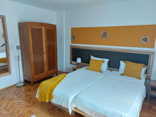 Stari BanovciPrenociste Biki的卧室配有一张带黄色枕头的大型白色床。