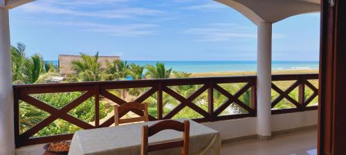Grand-PopoGuesthouse Bambou Beach的阳台配有桌子,享有海景。