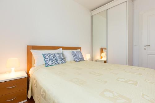 茨里克韦尼察Villa Mare Crikvenica的白色卧室配有一张带蓝色枕头的大床