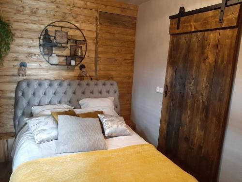 埃曼Jacuzzi huisje De Berenshoeve的一间卧室设有一张床和木墙