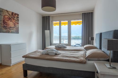 洛迦诺Tertianum Residenza Hotel & Ristorante Al Parco的一间卧室设有两张床和大窗户