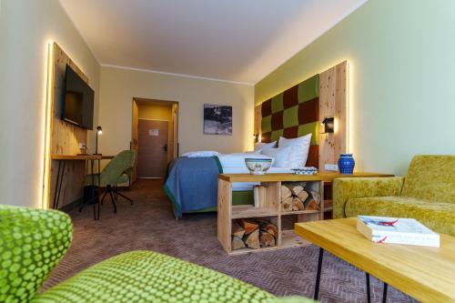 奥泊维森塔尔Rathaushotels Oberwiesenthal All Inclusive的酒店客房带一张床、一张桌子和椅子