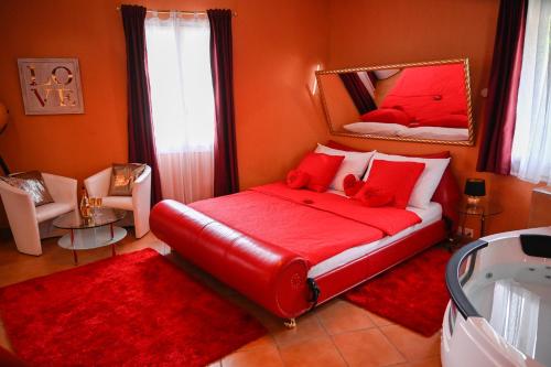 因特拉肯爱巢公寓的一间卧室配有红色的床和镜子