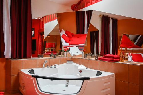 因特拉肯爱巢公寓的一间带红色枕头和大镜子的浴室